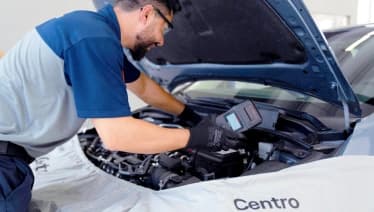 Mecânico avalia as condições de uma bateria veícular