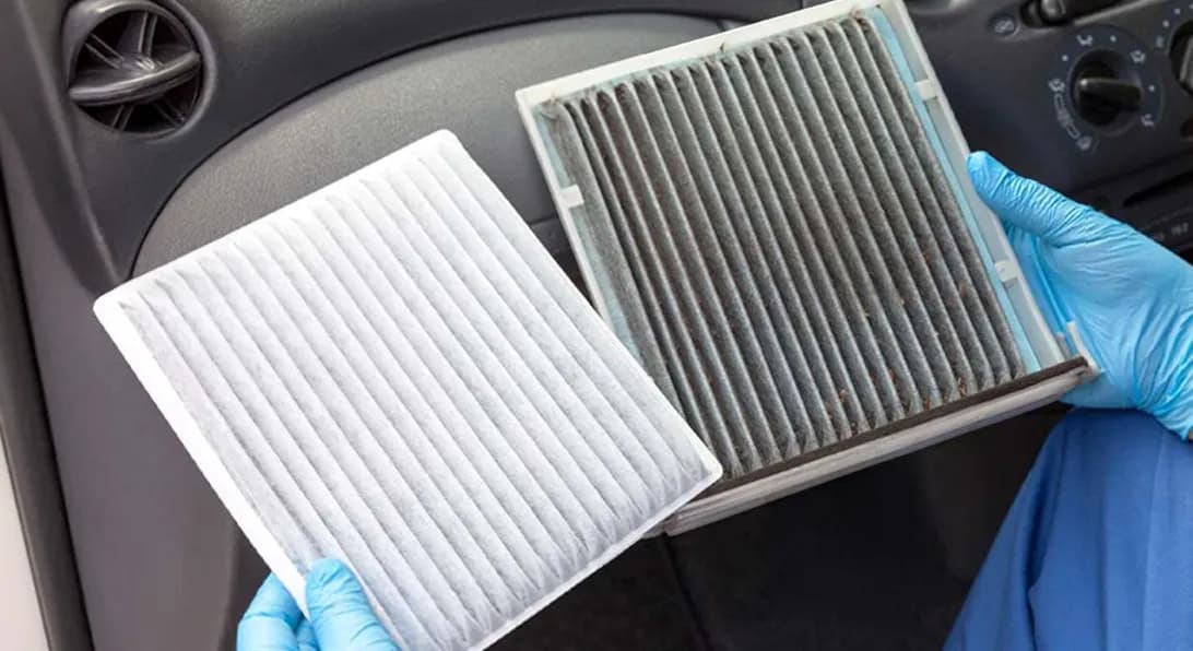 Comparação entre filtros de ar-condicionado automotivo: um novo, branco e limpo, ao lado de um usado, escuro e sujo.