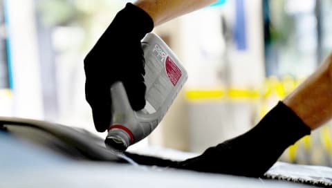 Especialista em um Centro Automotivo, mostra um detalhe no celular para uma cliente.